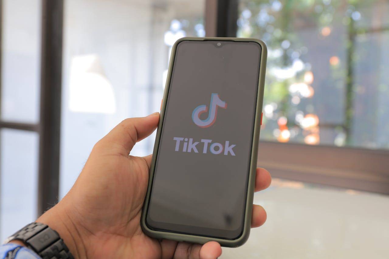 Mobile phone displaying TikTok app with text "How to Make Money on TikTok".